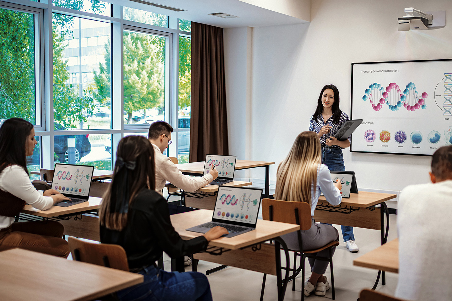 Docente e alunos usando Galaxy Books em sala de aula para aprendizado.
